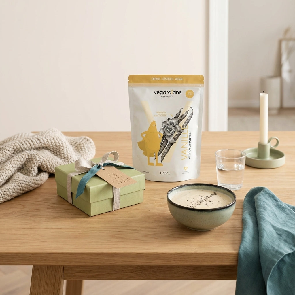 Wie lautet das dreiwortige Weihnachtszitat? Minimalistische Küchenaufnahme: Geschenkbox mit handgestempeltem Anhänger (nicht lesbar), Glas Wasser, veganer Shake im Morgenlicht